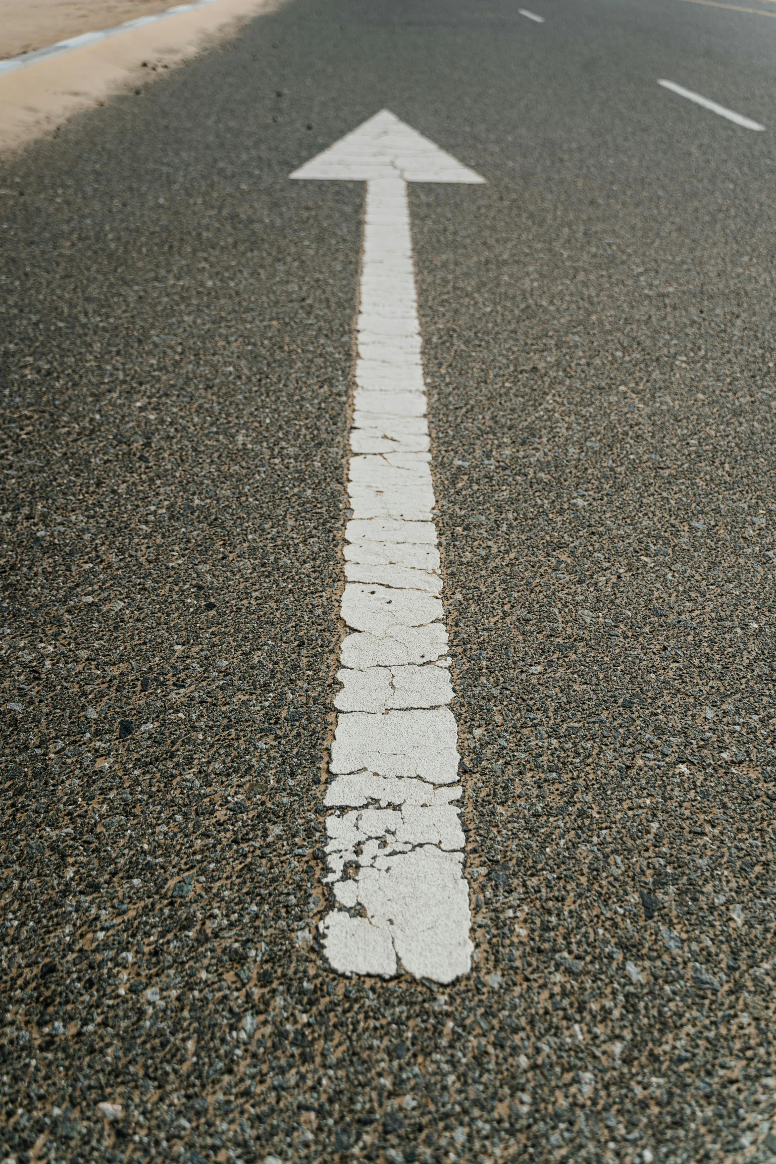 the white arrow is painted on the asphalt