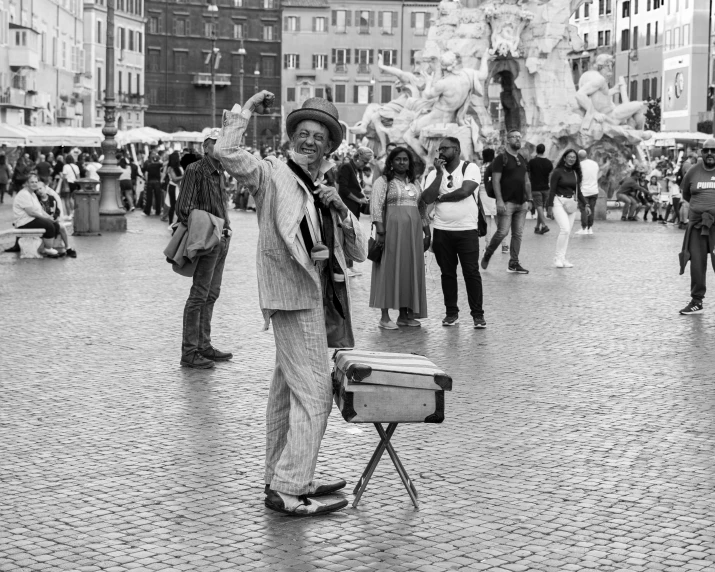 a man standing up while waving towards people in the street