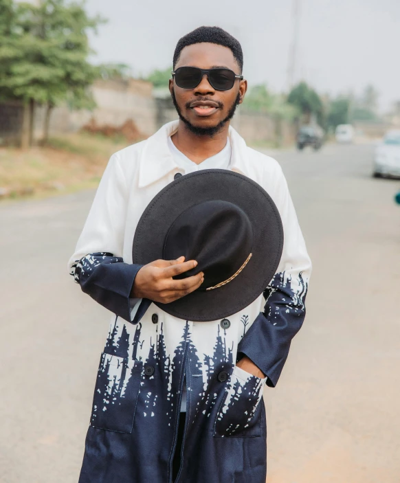 man in white shirt and black hat with car on road