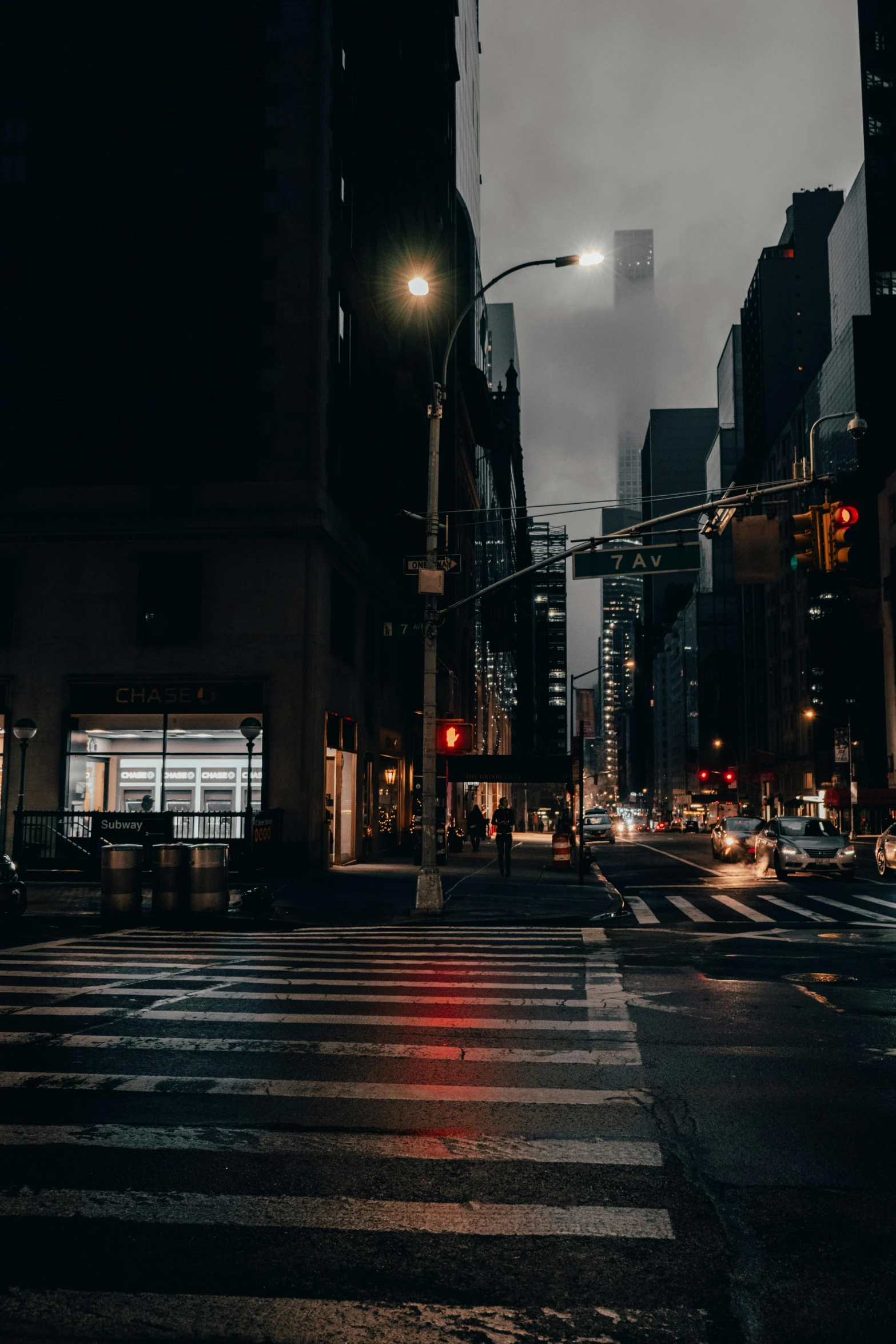 a city intersection at night with traffic, buildings and street lights