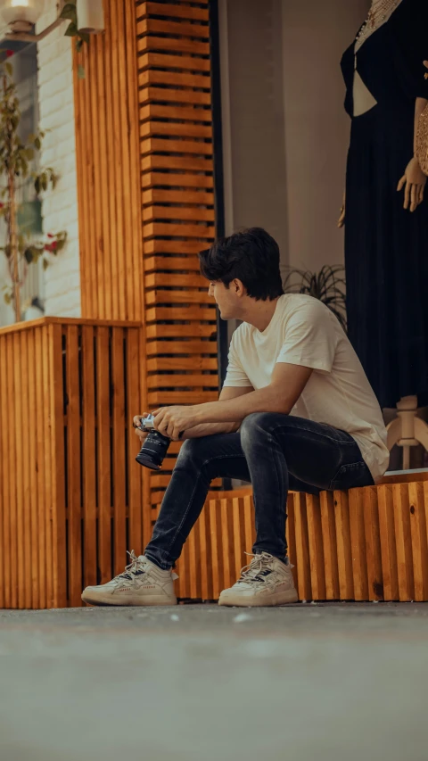 a man is sitting on a step while holding a camera