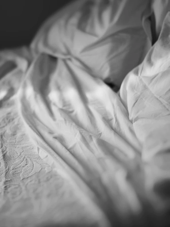 a black and white po of a bed with two pillows and sheets