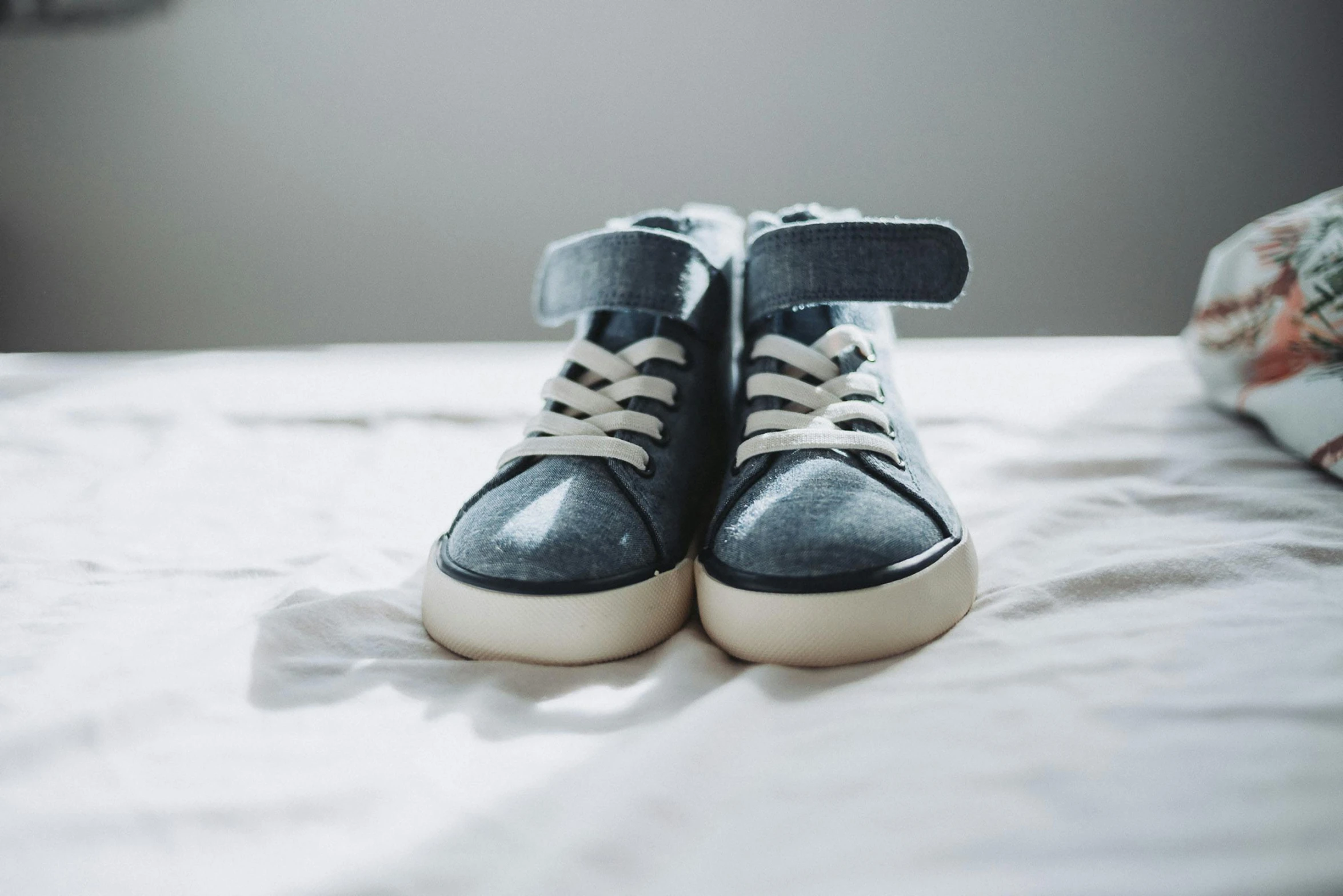 a pair of black shoes are on the bed