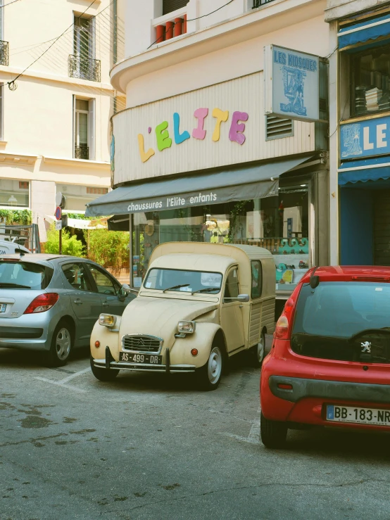 three small cars are parked in front of a little restaurant