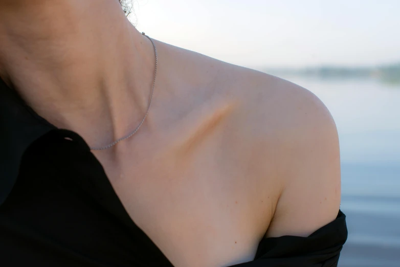 a close up s of a woman in a black dress wearing an elegant diamond necklace