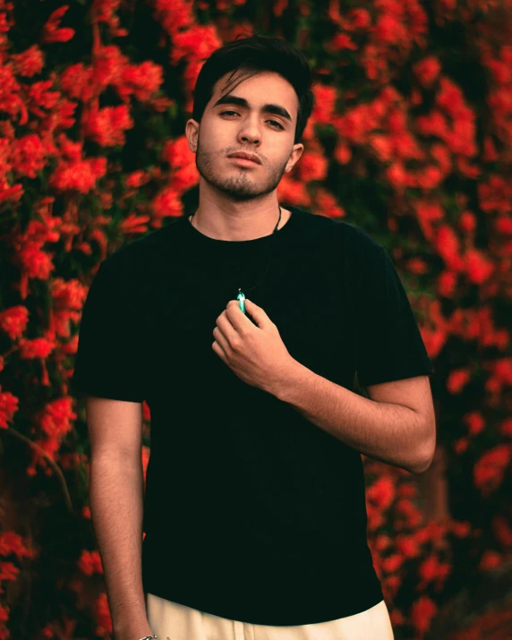 a guy that is standing in front of some flowers
