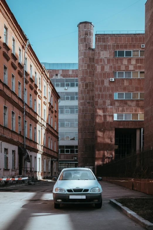 a car is parked next to tall buildings