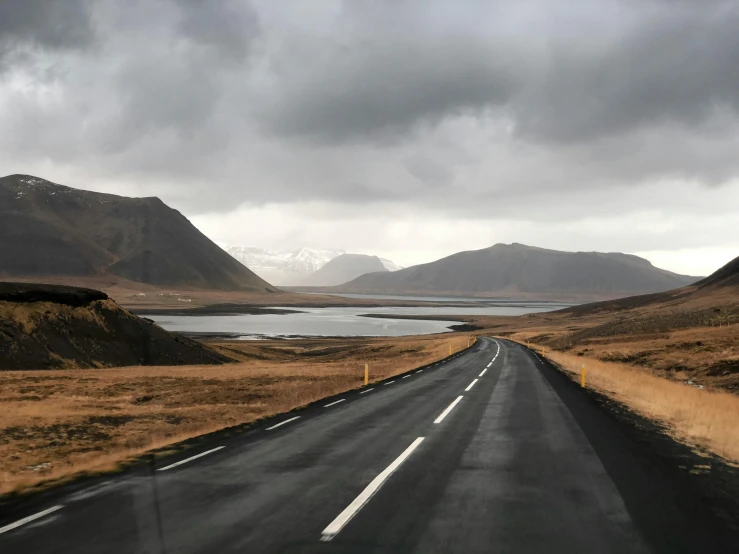 the road is empty by a lot of mountains