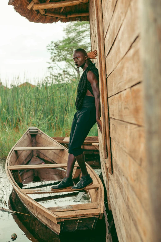 a man is standing on the side of a canoe