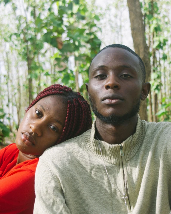 a couple sitting next to each other in a wooded area