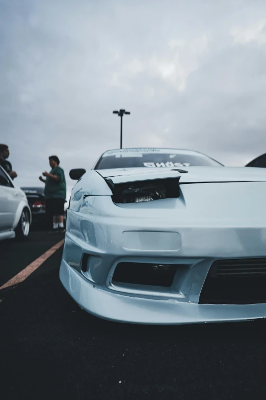 the front of a white sports car in a parking lot