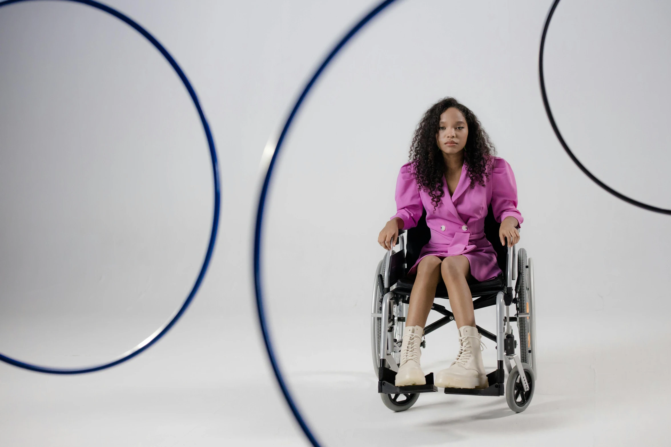 woman in pink sitting in a wheel chair with blue rims around her