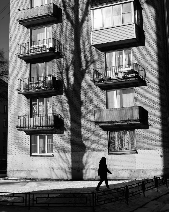 a person walks on a sidewalk in front of a building