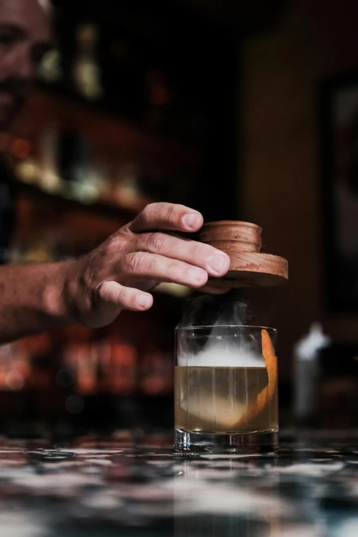 someone is putting soing in a glass that has been placed on a counter