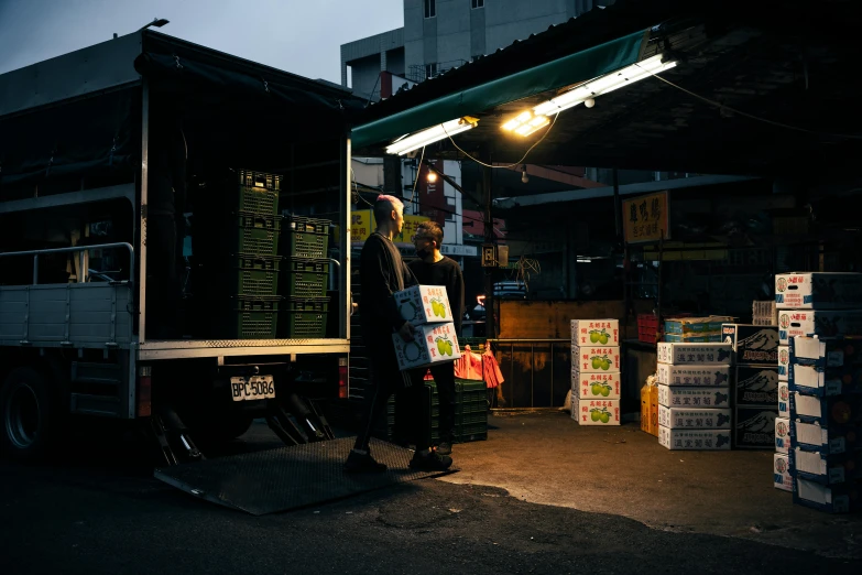 a man standing outside of a truck at night