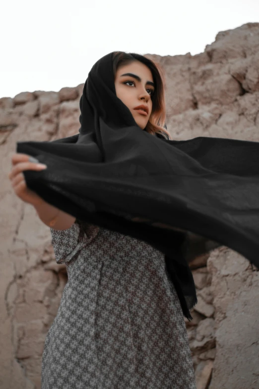 woman wearing a veil in the desert against rocks