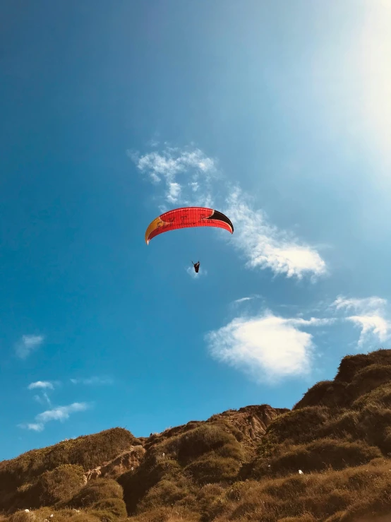 a red kite flying high up into the air