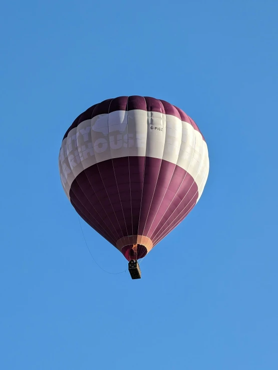 a purple and white  air balloon that is flying