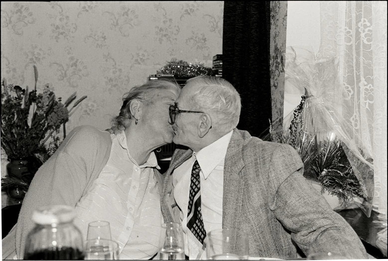 an old man and woman kissing each other