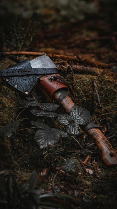 a knife on top of some wood with grass