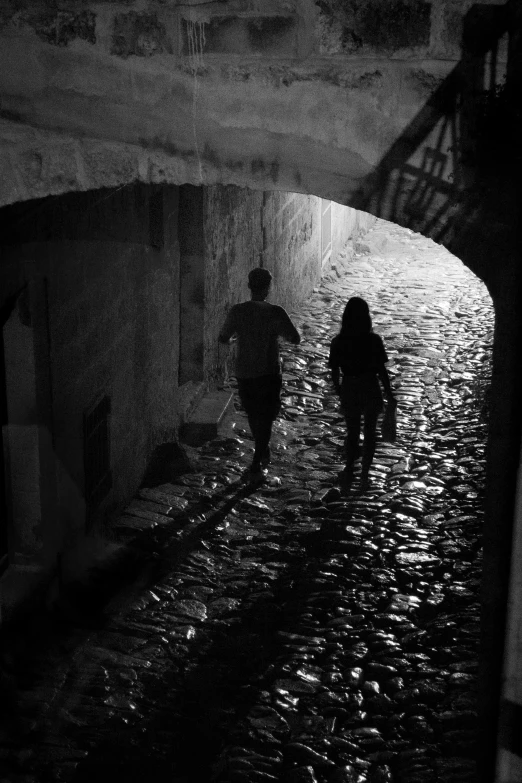 the people walk underneath an arch as they are dark