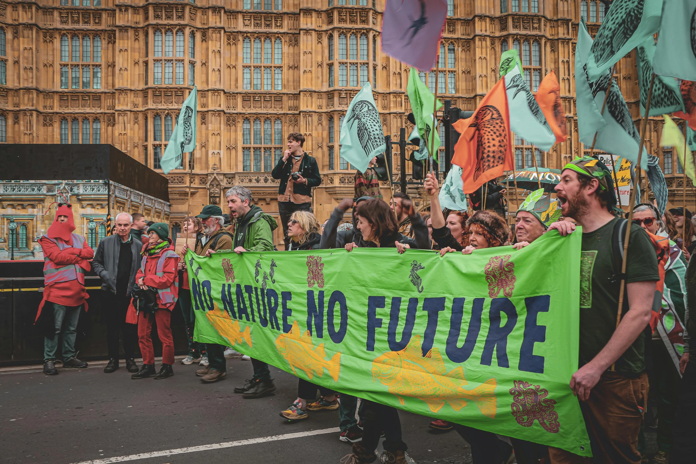 a group of people are holding a large banner and a flag