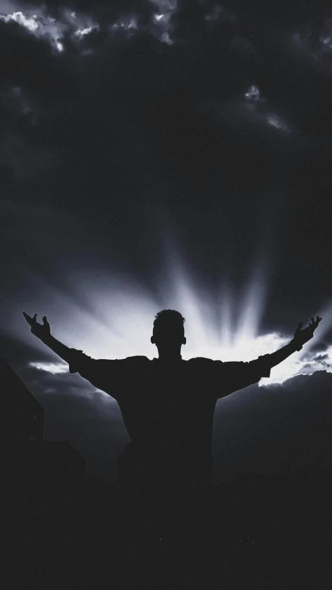 a man is silhouetted against an ominous sky