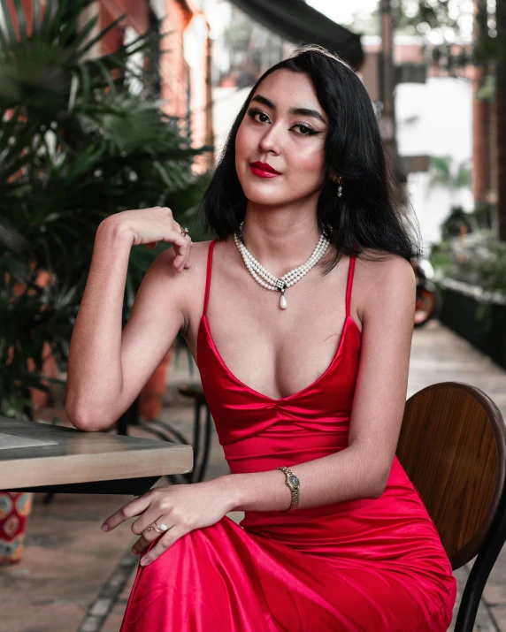 a very  woman in a red dress sitting down