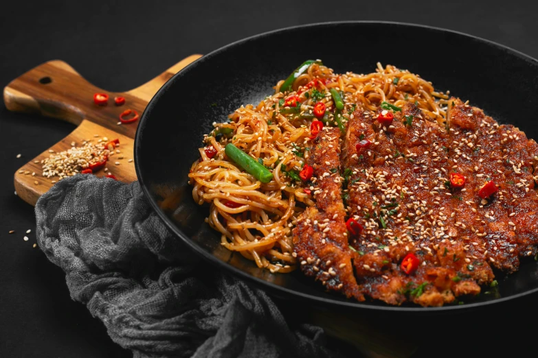 a wok is filled with stir fry noodles and vegetables