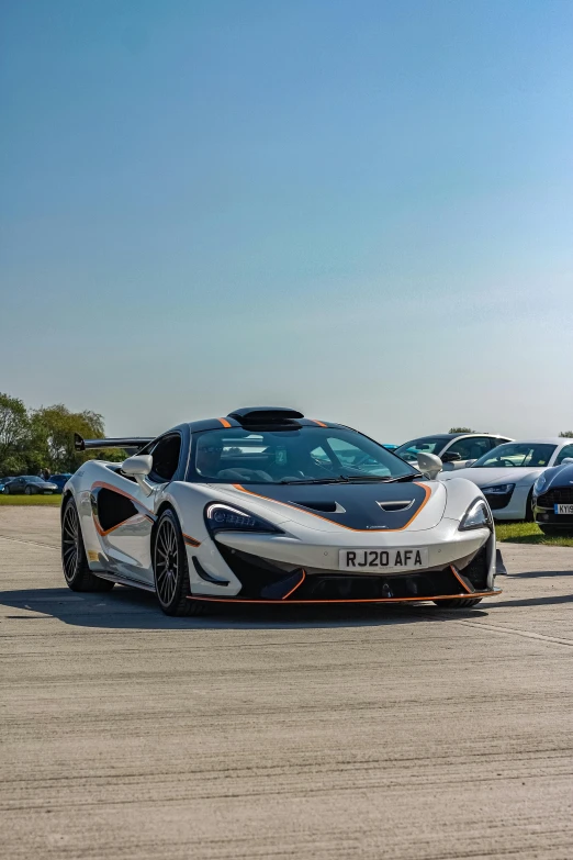 a person is standing near some very big sport cars