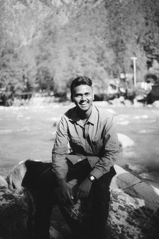 black and white po of man sitting on rocks