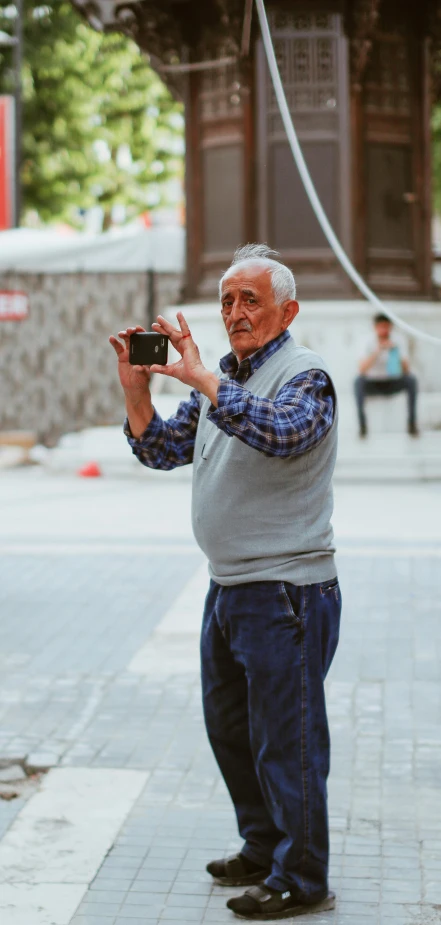 an older man holding up his digital camera