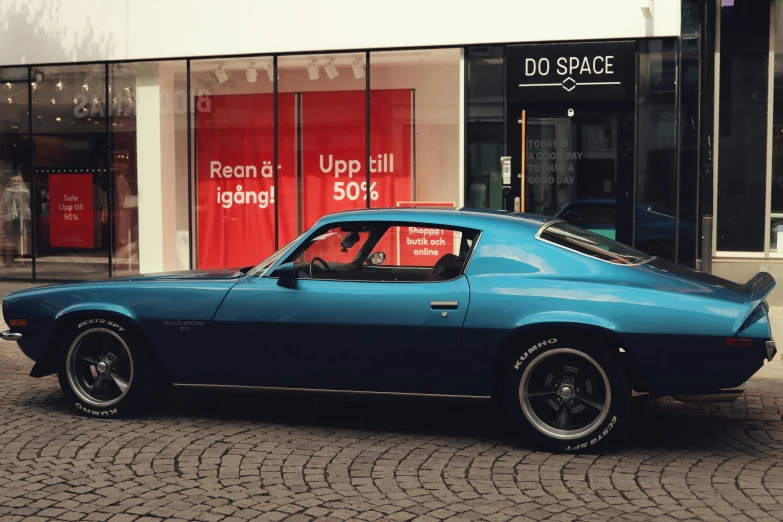 a car is parked on the street in front of stores