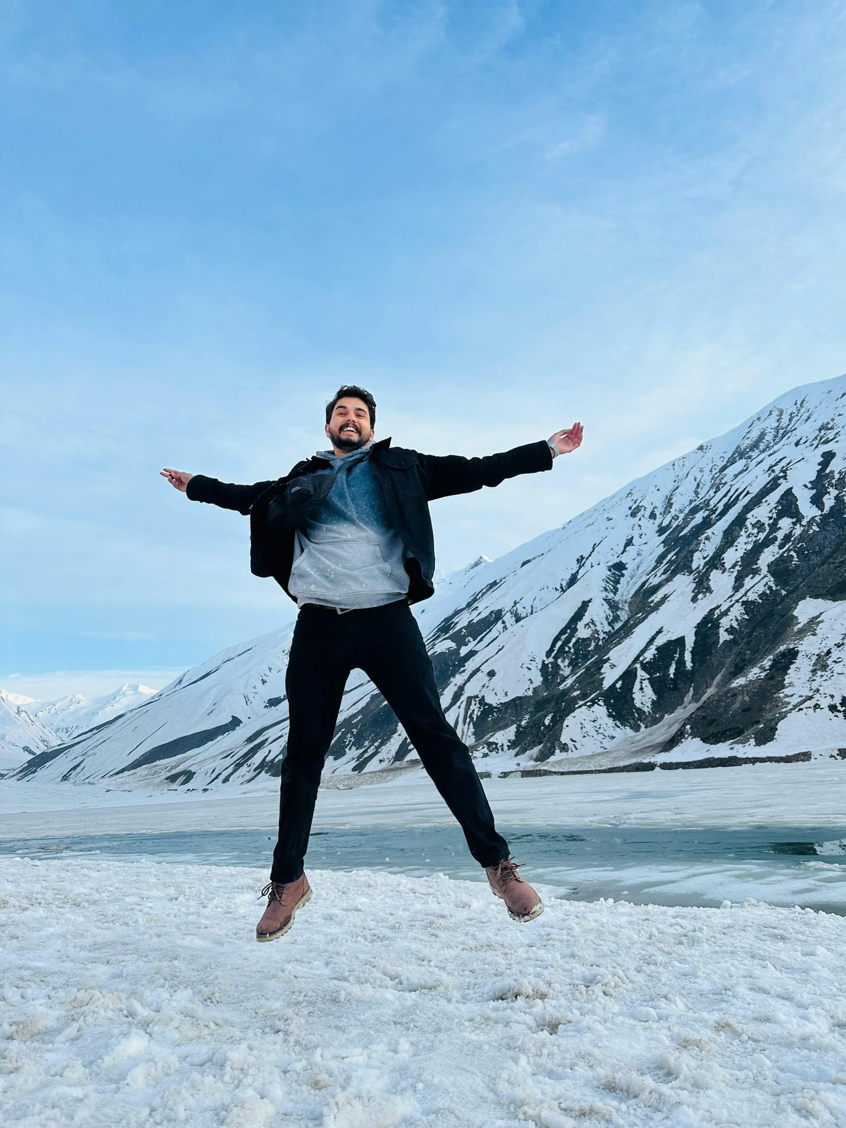 a man in an all - black jacket jumps high into the air