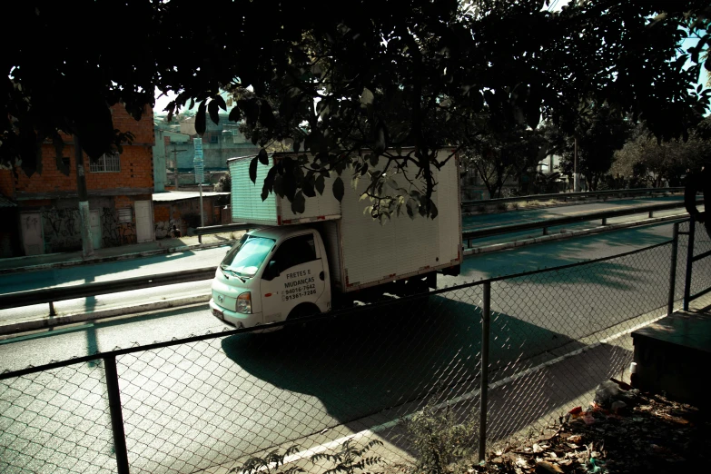a white box truck parked near a fence