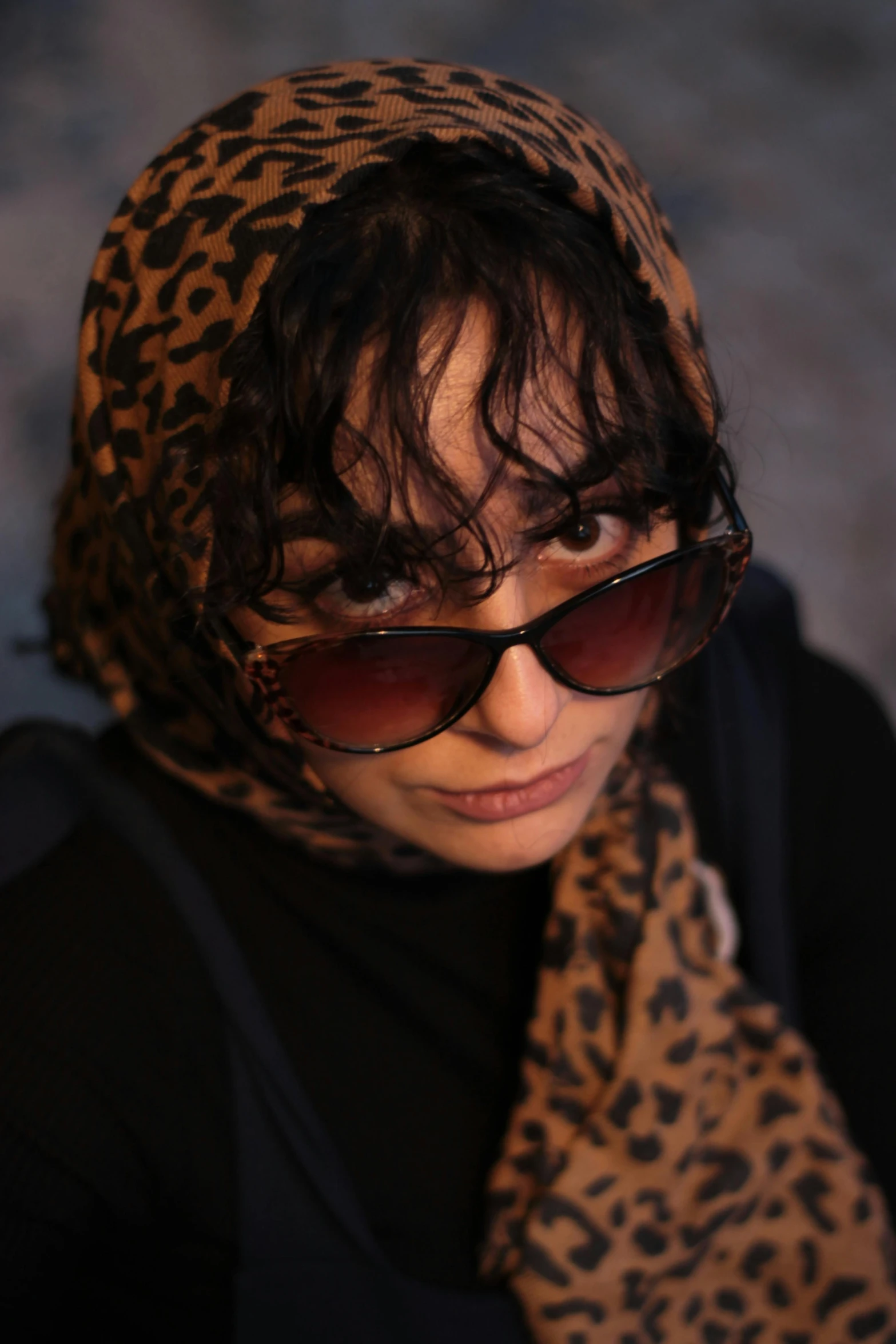 the woman is wearing sunglasses with a leopard print head covering