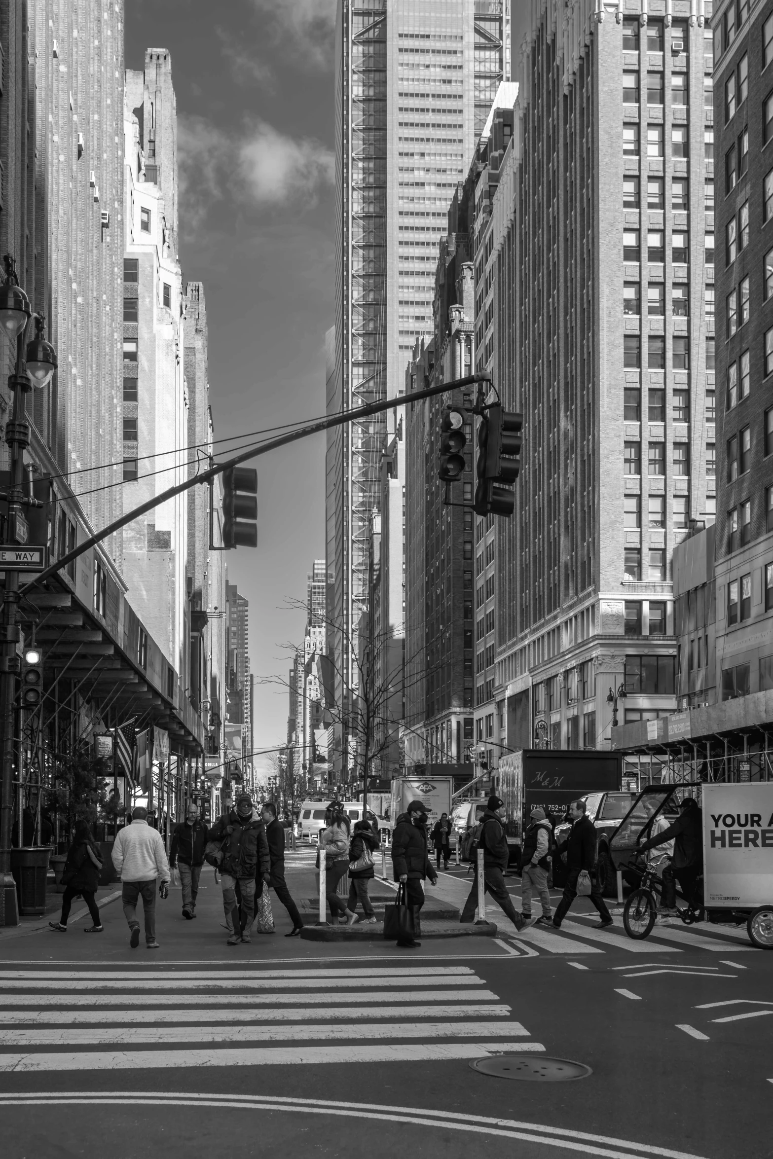 an intersection in the city with many people crossing and holding umbrellas