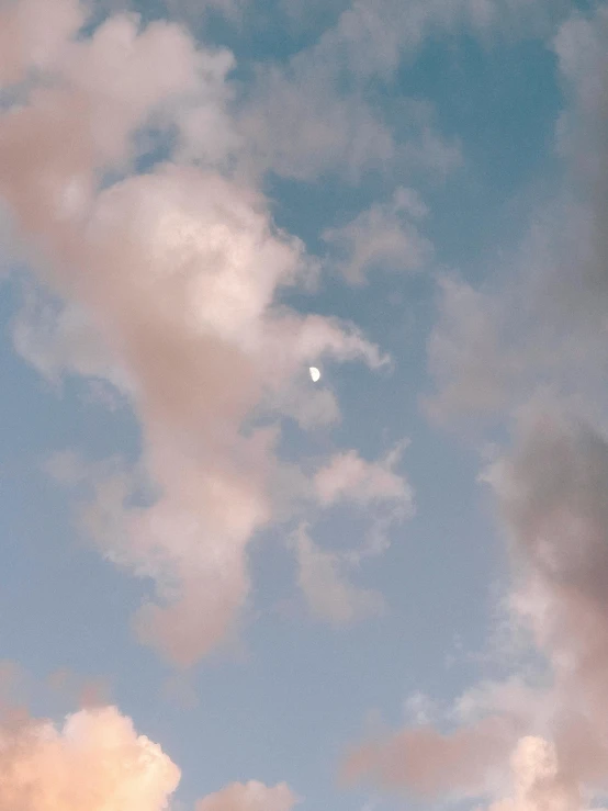 a plane flying high above the sky with clouds