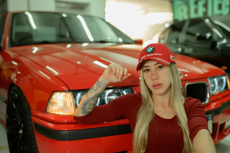 girl with tattoos stands next to car in garage