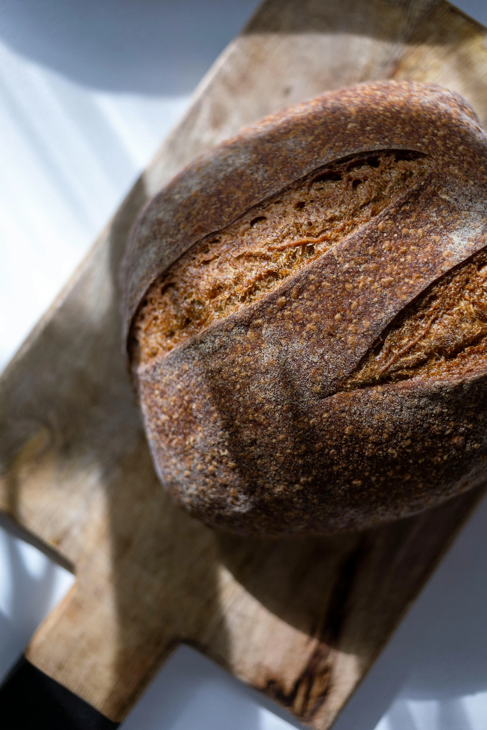 a loaf of bread on top of a wooden  board