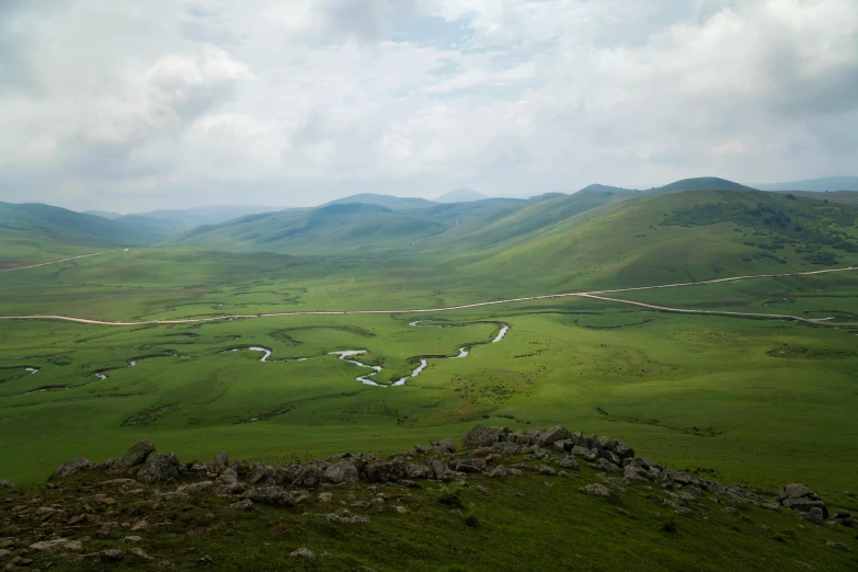 green rolling hills with roads winding into the valley