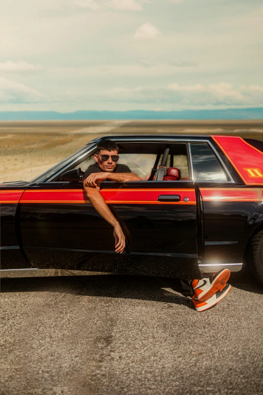 a man rides in the car while sitting on a skateboard