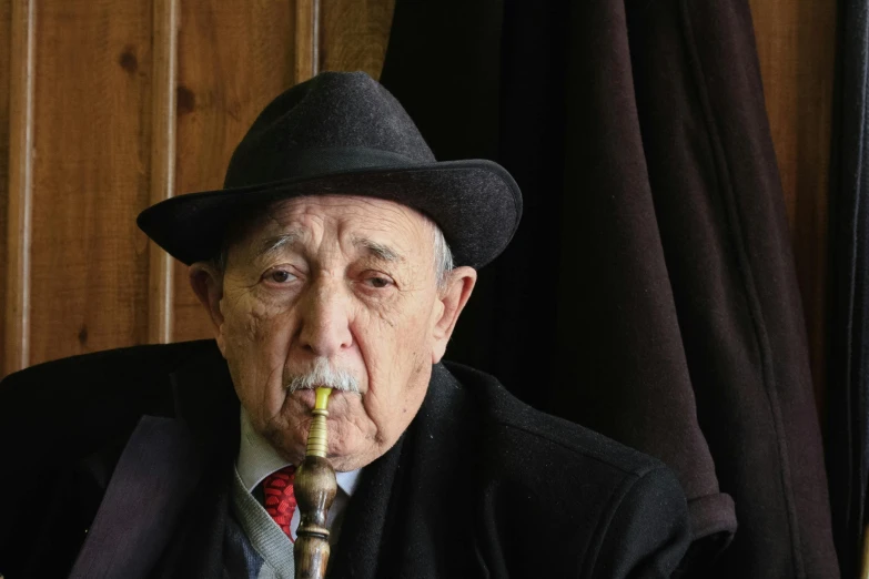 an older man with a cane in his mouth