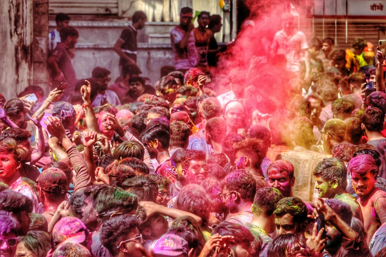 a crowd of people throwing colorful powder and playing