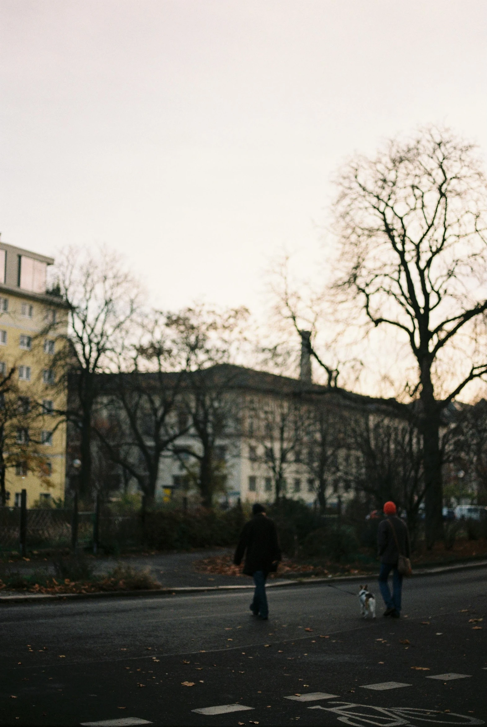 two people walking down the street on a cloudy day