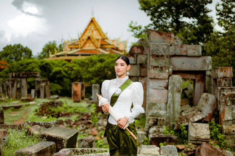 a woman in a white blouse and green skirt is holding a pipe