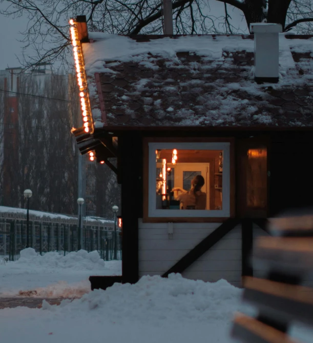 a man stands in the door of his home with an illuminated light pole