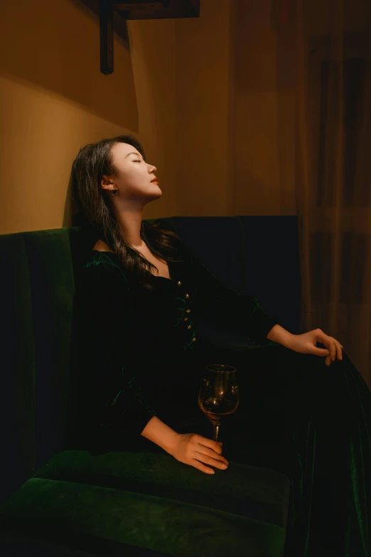 a close up of a person sitting on a couch with wine glass