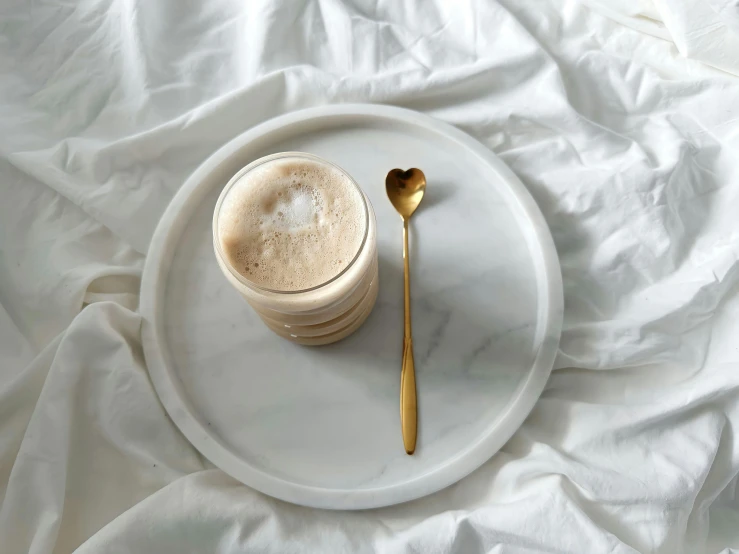 two small cups and a spoon on a white plate