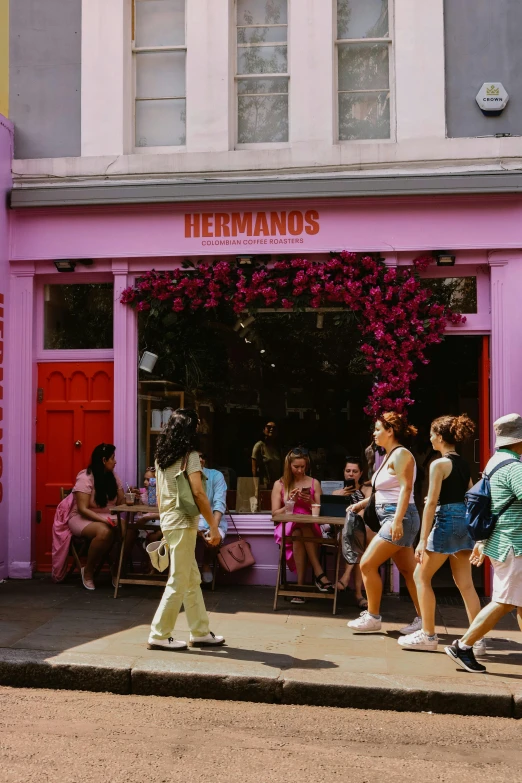 a group of people are walking past shops